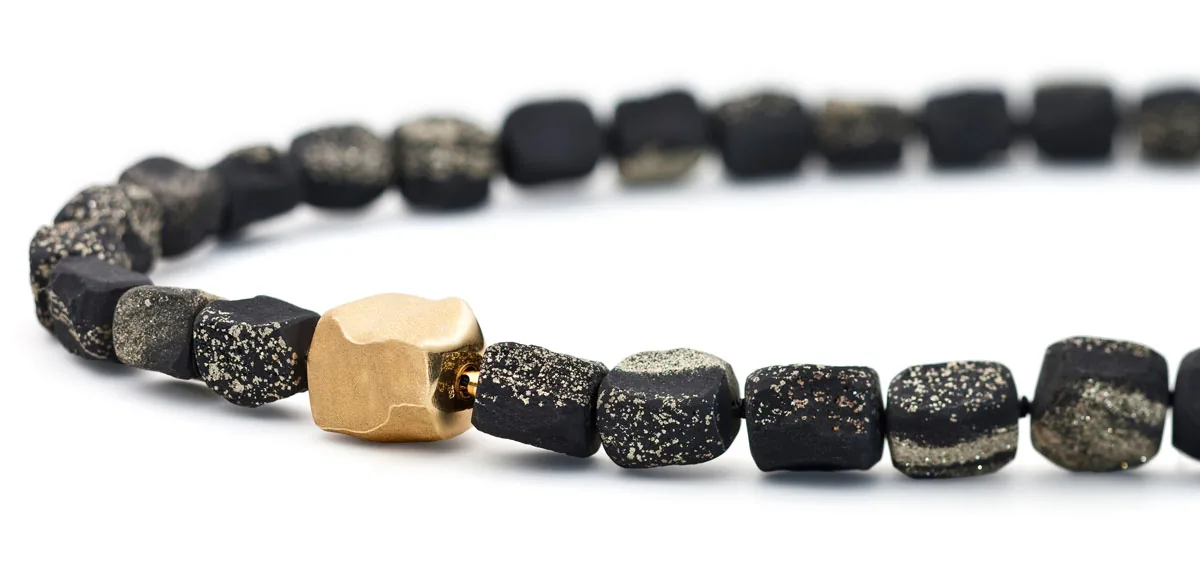 Necklace of dark rough stones with a gold element